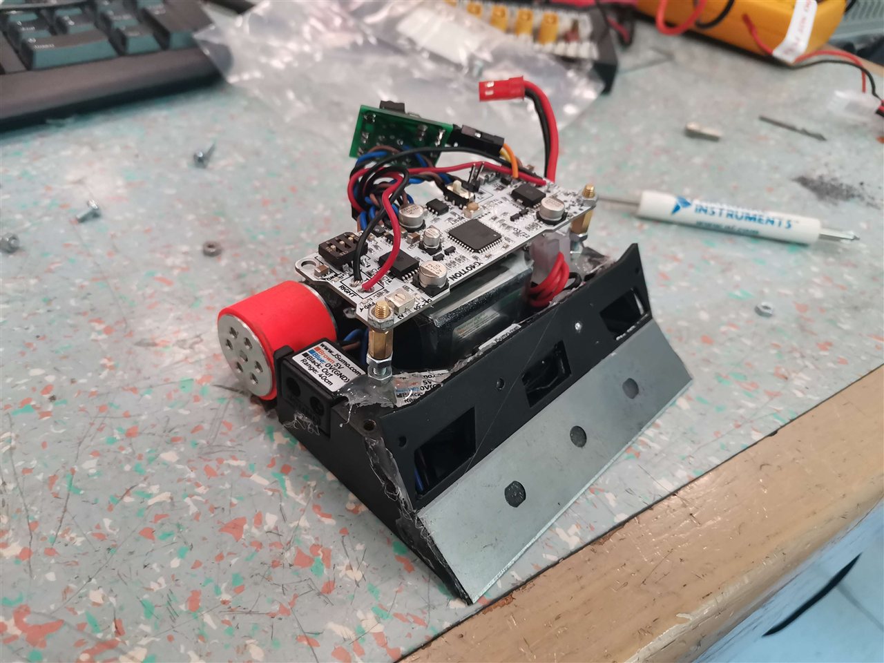 Competition sumo robot with exposed control electronics on a workbench